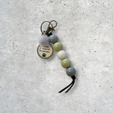 Beaded keychain with a paw print charm on a textured surface
