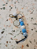 Keychain with beads and a tag on a textured surface