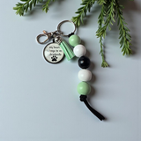 Beaded keychain with paw print design on a light gray background