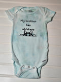 Light blue baby onesie with text and a cat illustration on a white background