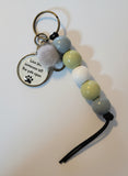Keychain with beads and a tag on a wooden surface