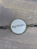 Lanyard with a round badge featuring '#girlboss' on a wooden surface
