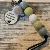 Keychain with beads and a motivational tag on a wooden surface