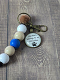Keychain with beads and a chihuahua tag on a wooden surface