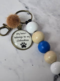 Keychain with colorful beads and a paw print charm on a marble surface