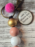 Keychain with colorful beads and a circular tag on a wooden surface
