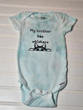 Light blue baby onesie with text and a cat illustration on a white background