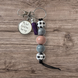 Keychain with beads and a tag on a wooden surface