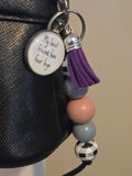 Keychain with beads and a tag on a black surface
