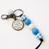 Keychain with blue and white checkered beads and a metal tag on a white background