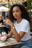 Woman sitting at an outdoor cafe holding a cup of coffee