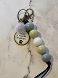 Keychain with beads and a paw print charm on a marble surface