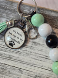 Keychain with a tag reading 'My heart belongs to my Labradoodle' on a wooden surface